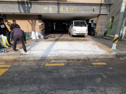건물 지하주차장 입구 앞 완만한 경사로에 콘크리트를 새로 타설해 흰색으로 마감한 모습